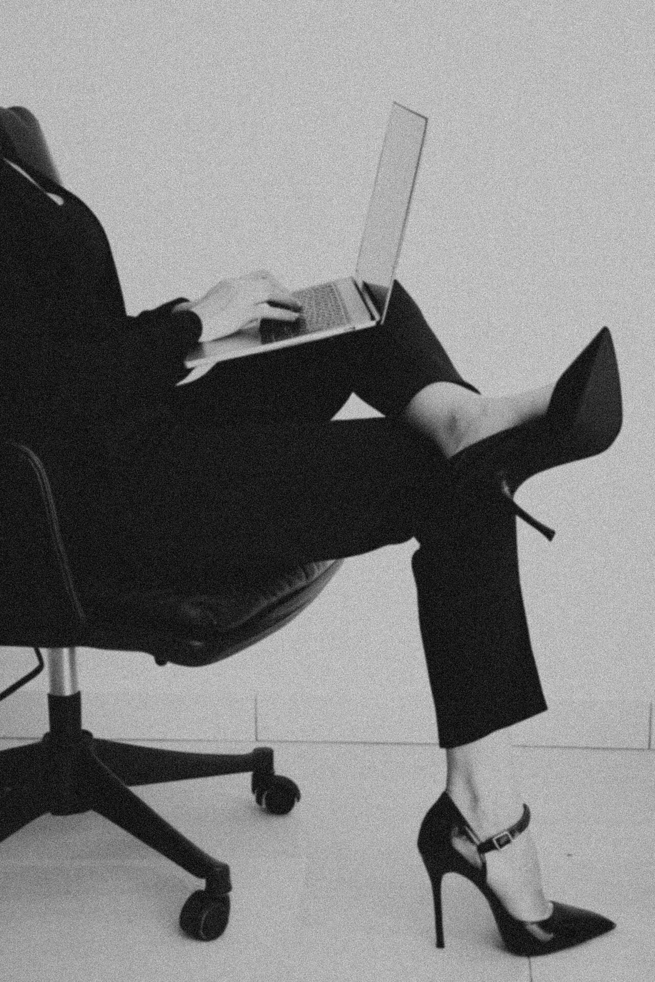 Frau mit Laptop im Bürostuhl, Schwarz-Weiß