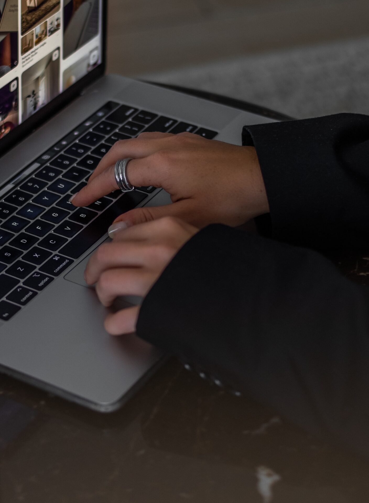 Hände tippen auf Laptop-Tastatur mit Ringen
